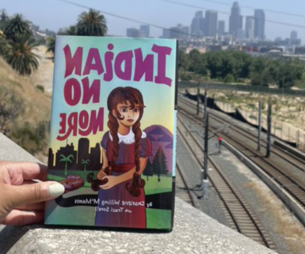 Indian No More book with a view of train tracks and downtown skyline
